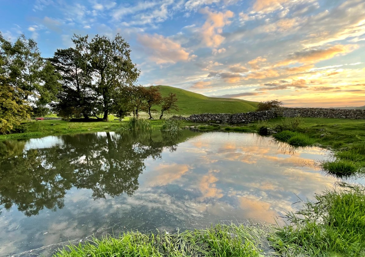 Holidays with beautiful Peak District views- the sky mirrored on the water at Gateham Grange